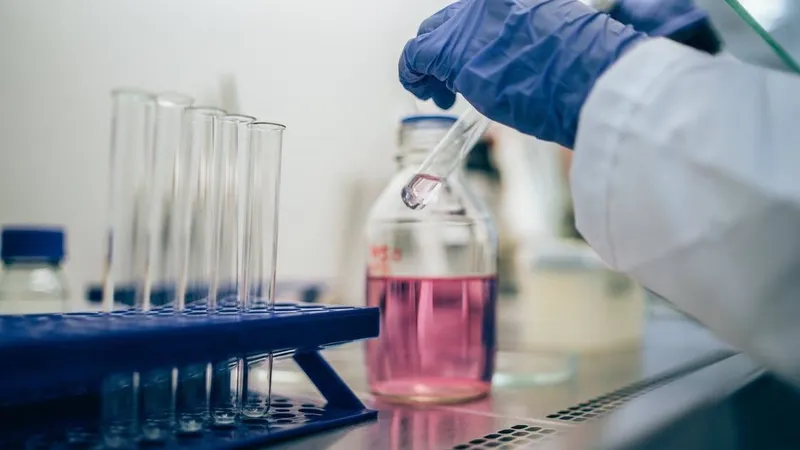 Laboratory worker handling test tubes with chemicals, illustrating industrial chemical exposure as a risk factor for leukemia