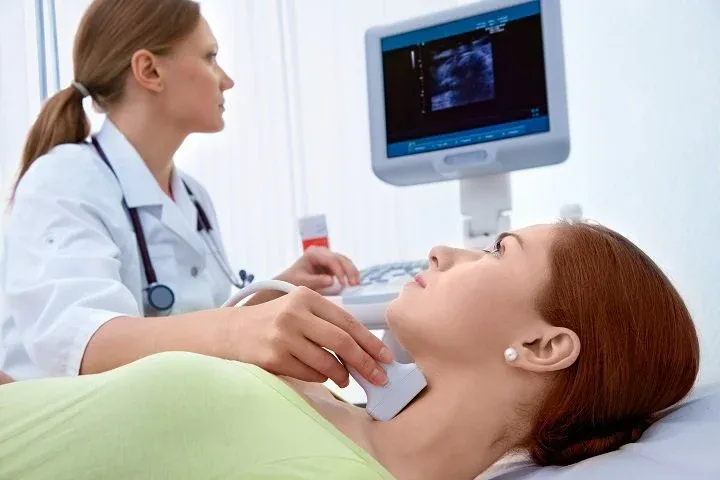 Doctor performing an ultrasound examination of a patient’s neck to evaluate for laryngeal or thyroid abnormalities
