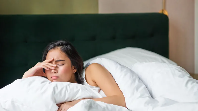 Woman feeling weak in bed due to pernicious anemia, a high-risk factor for stage 3 stomach cancer