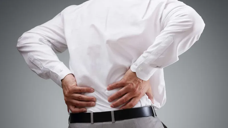 Connective Tissue Cancer Man clutching his lower back in pain, illustrating persistent or nocturnal back pain that may indicate sarcoma or another serious condition
