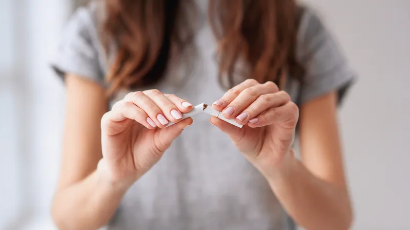 Woman breaking cigarette to reduce risk of meningioma and improve brain health
