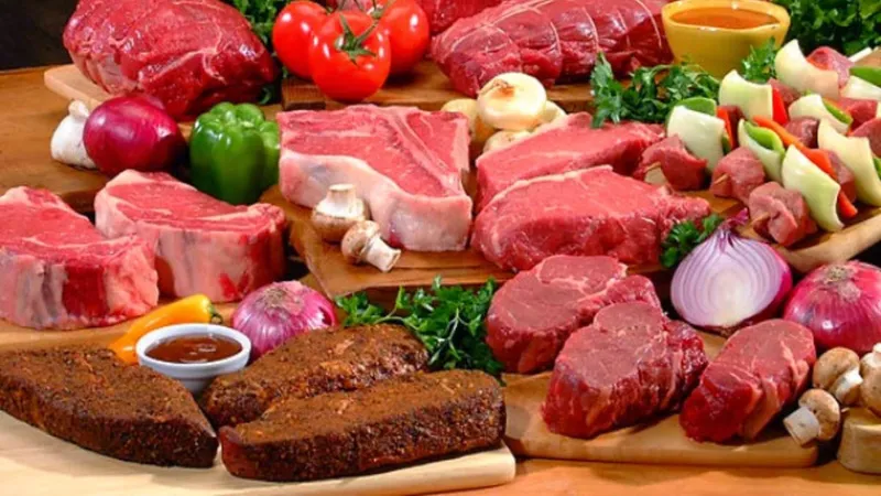 Table full of various red meats showing increased cancer risk from high red meat consumption