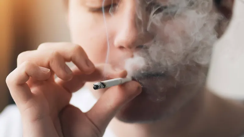 Close-up of a person smoking a cigarette, highlighting the importance of avoiding tobacco for patients with acute blood cancer (acute leukemia)