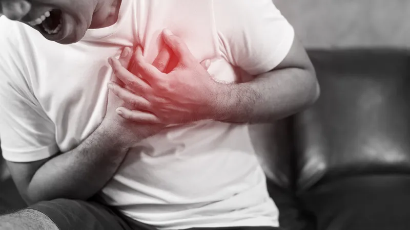 Man clutching chest experiencing pain, a common symptom of thymoma