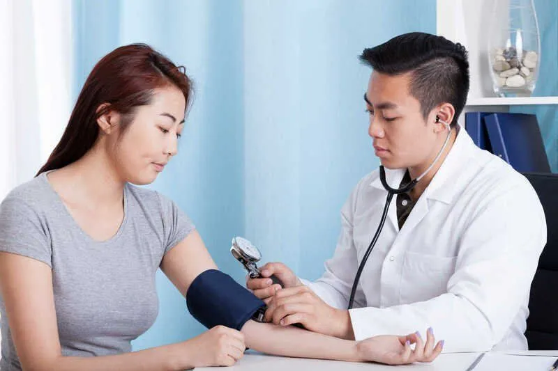 Doctor measuring patient’s blood pressure for hypertension diagnosis