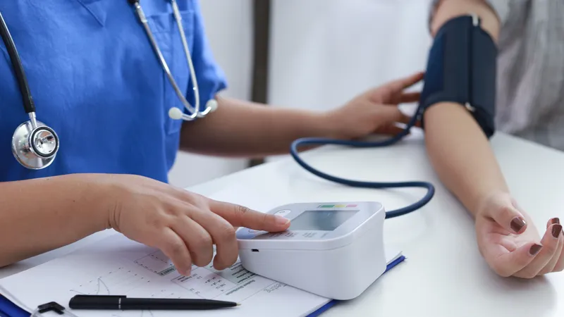 Healthcare professional checking patient’s blood pressure with a digital monitor