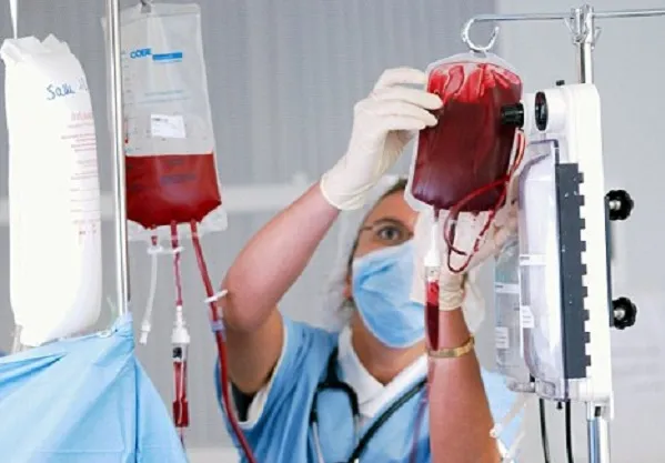 Doctor preparing blood transfusion for patient with severe anemia caused by blood clotting disorder