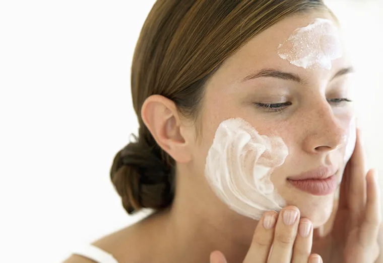 Woman cleansing her face to prevent acne and maintain healthy skin
