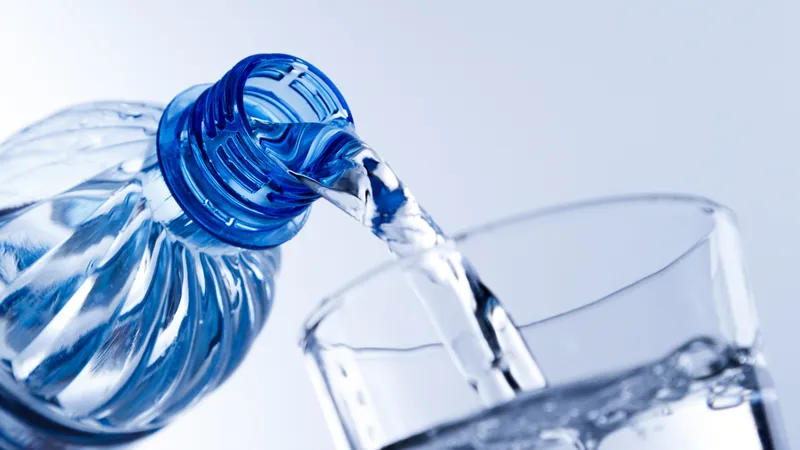 Pouring water into a glass to illustrate how staying hydrated increases blood volume and helps prevent low blood pressure