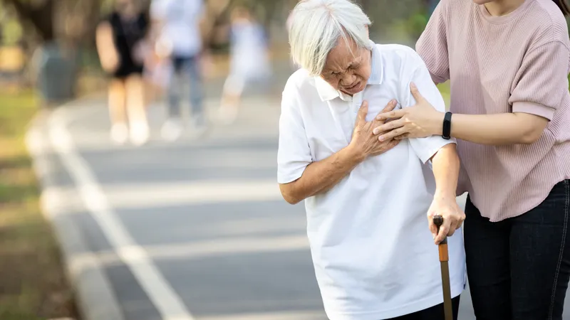 An elderly woman experiencing shortness of breath and chest pain, signs of a possible heart attack.