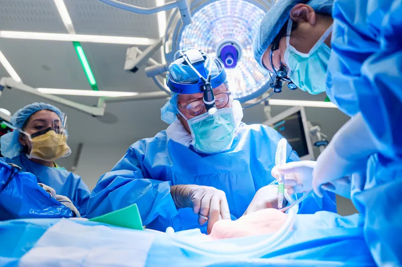 Surgeons performing a heart transplant operation in a modern operating room