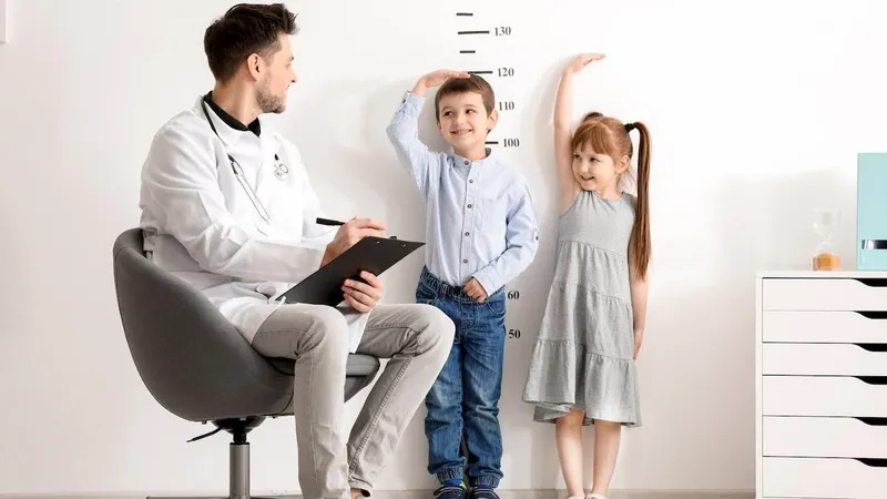 Doctor measuring children’s height to evaluate growth and screen for pituitary dwarfism
