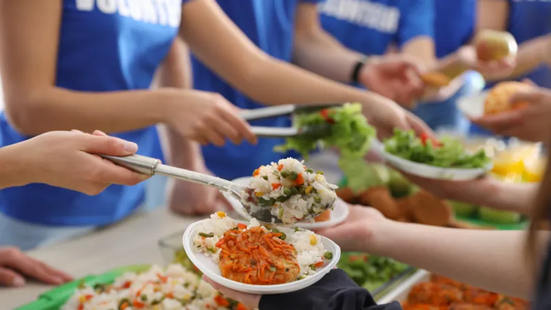 Volunteers serving balanced meals with vegetables and rice, emphasizing the importance of proper nutrition to prevent low blood pressure