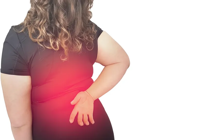 Overweight woman experiencing lower back pain due to obesity