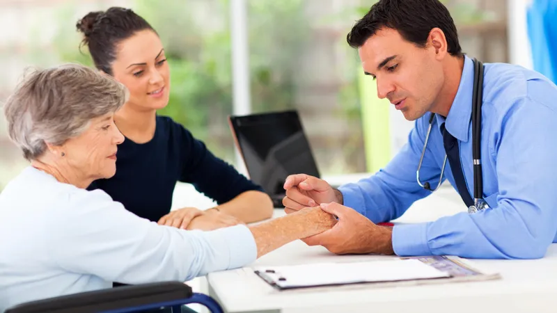 Doctor examining an elderly patient’s hand and discussing test results for diagnosing scleroderma