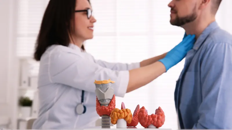 Doctor examining patient’s thyroid gland as a possible cause of secondary hypertension