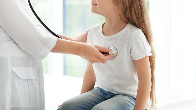 Doctor using a stethoscope to examine a child's heartbeat for arrhythmia diagnosis and treatment