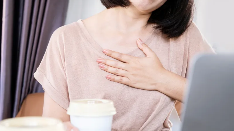Heart Palpitations Woman holding her chest experiencing rapid heartbeat or palpitations