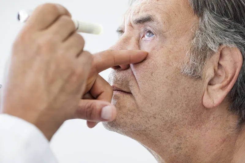 An elderly man undergoing an eye examination as older adults are at higher risk of visual impairment.