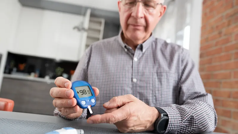 Homepage Man checking blood glucose level with glucometer for diabetes diagnosis