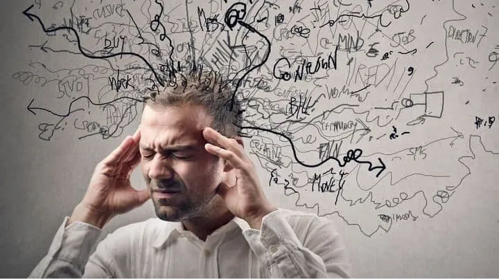 Homepage Stressed man holding his head with messy thoughts symbolizing stress-induced hair loss